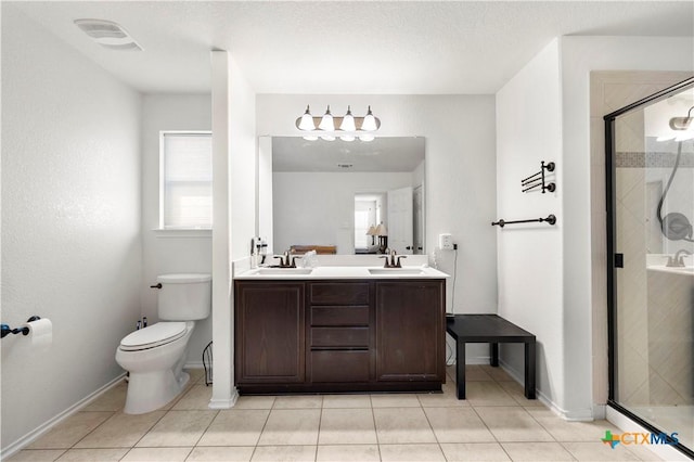 full bathroom featuring double vanity, a shower stall, toilet, and a sink