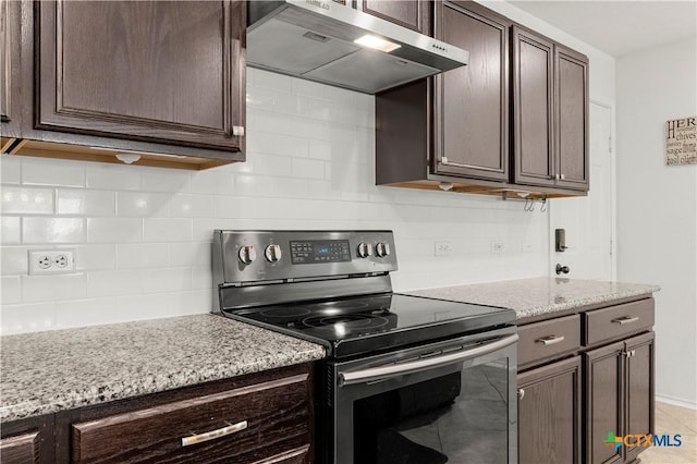 kitchen featuring tasteful backsplash, ventilation hood, dark brown cabinetry, light stone counters, and electric range