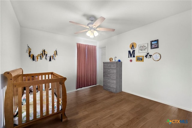 9220 Sage Valley Dr, Temple, TX 76502 - bedroom with wood finished floors, baseboards, a crib, and a ceiling fan
