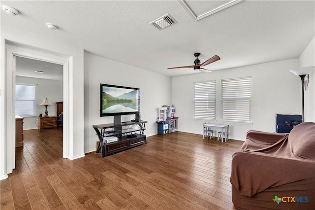 sitting room featuring visible vents, hardwood / wood-style flooring, a textured ceiling, baseboards, and ceiling fan