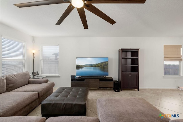 tiled living room with plenty of natural light, baseboards, and ceiling fan