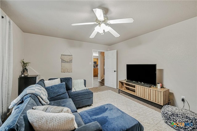carpeted living room with a ceiling fan