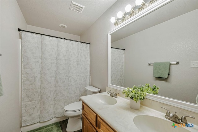 full bath featuring visible vents, a sink, double vanity, and toilet