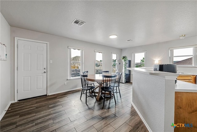 dining space featuring visible vents, baseboards, and dark wood-type flooring