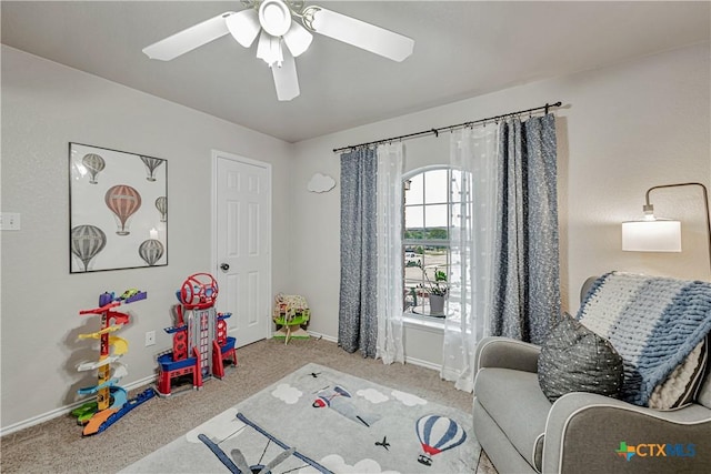 recreation room with carpet floors, baseboards, and a ceiling fan