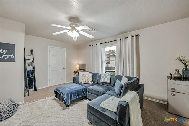 living room featuring visible vents, carpet floors, baseboards, ceiling fan, and a textured ceiling