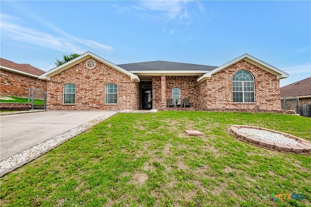 ranch-style house featuring fence, a front lawn, and brick siding