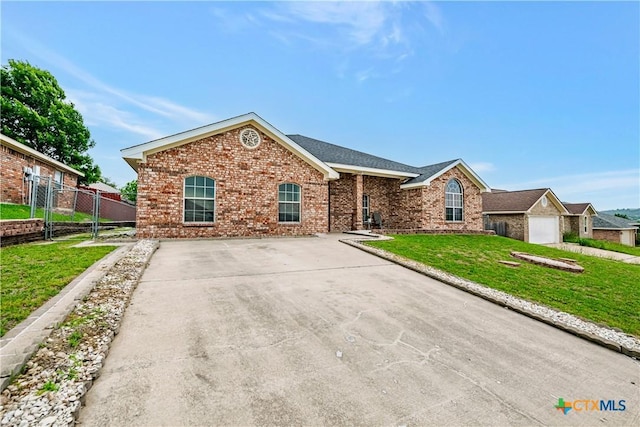 ranch-style house with brick siding, fence, a front yard, and roof with shingles