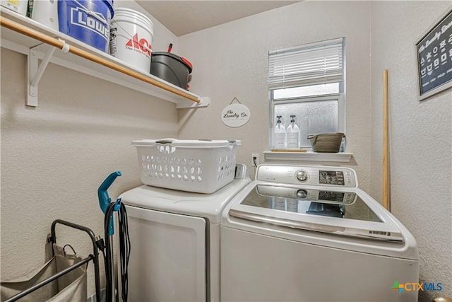 laundry area with a textured wall, laundry area, and washer and dryer