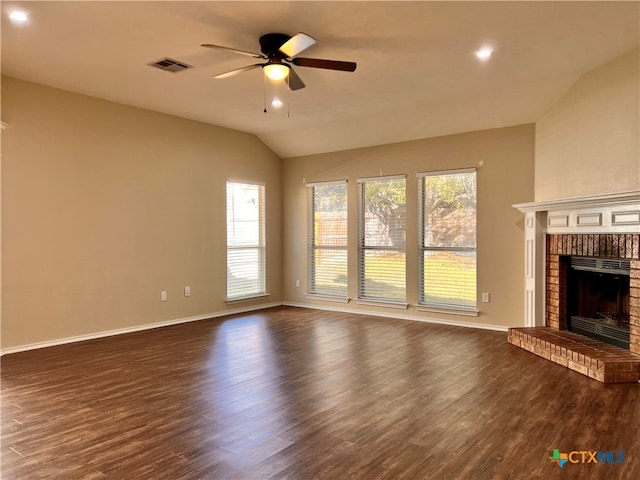 unfurnished living room with dark wood-type flooring, ceiling fan, vaulted ceiling, and a brick fireplace