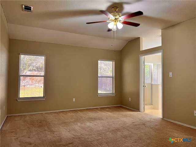 carpeted empty room with ceiling fan and vaulted ceiling