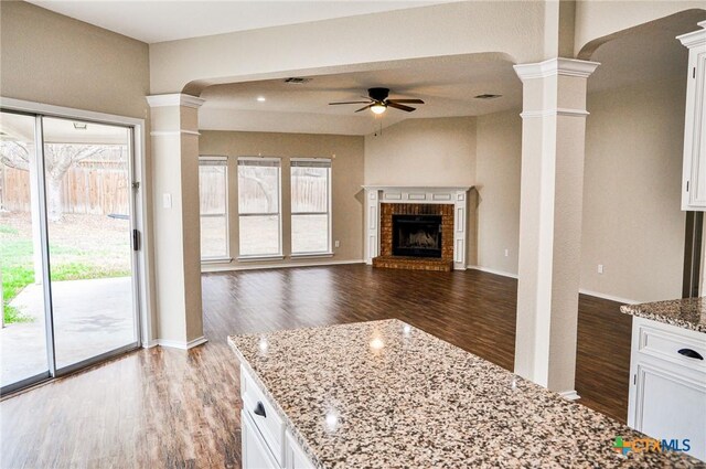 kitchen with stainless steel appliances, white cabinetry, ornate columns, and dark hardwood / wood-style flooring