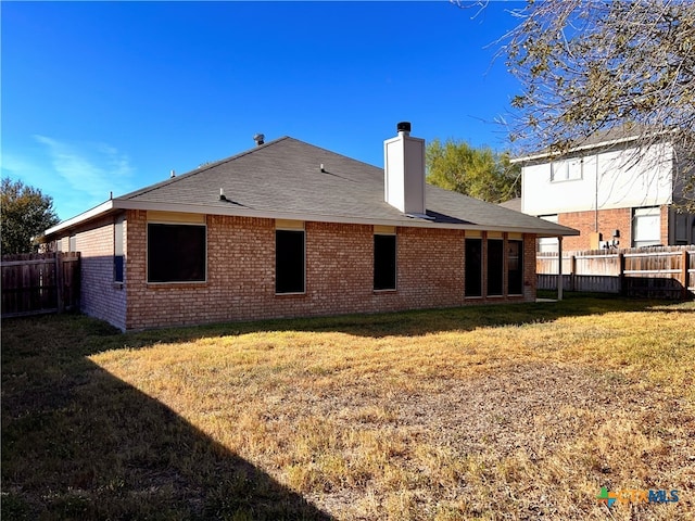 rear view of house featuring a yard