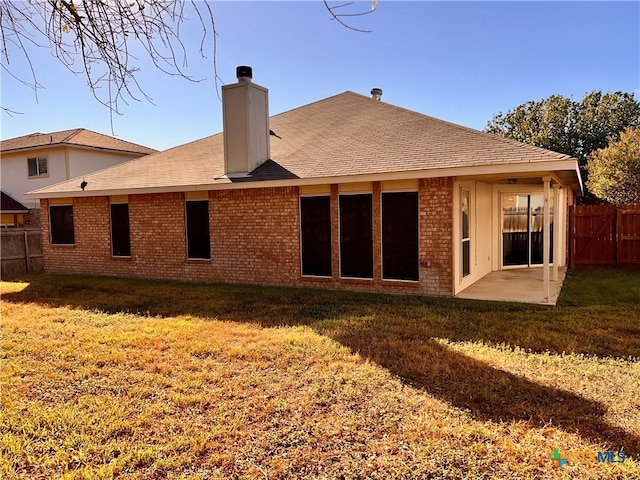 rear view of property featuring a patio and a yard