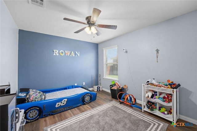 bedroom featuring wood finished floors, baseboards, and ceiling fan