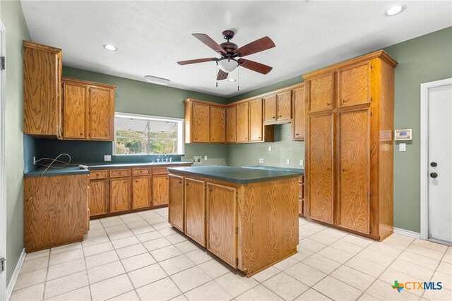 803 S Converse St, Flatonia, TX 78941 - kitchen featuring a kitchen island, ceiling fan, dark countertops, brown cabinets, and recessed lighting