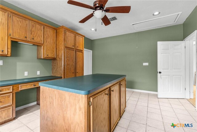 803 S Converse St, Flatonia, TX 78941 - kitchen with light tile patterned floors, ceiling fan, dark countertops, brown cabinetry, and a center island