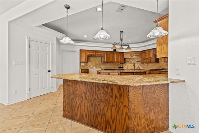 803 S Converse St, Flatonia, TX 78941 - kitchen with brown cabinetry, tasteful backsplash, a raised ceiling, light stone counters, and recessed lighting