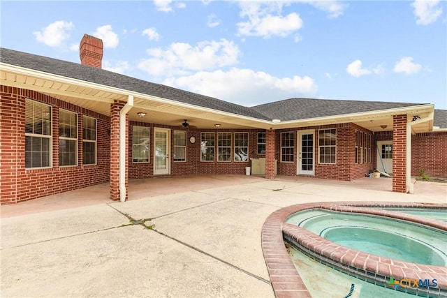803 S Converse St, Flatonia, TX 78941 - rear view of property with an in-ground hot tub, brick siding, and a patio area