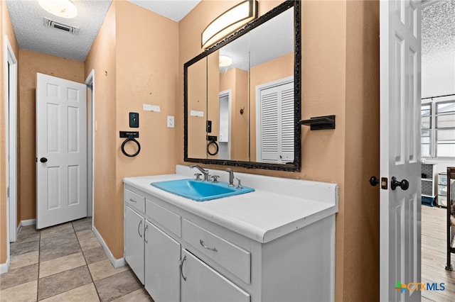 614 Cedar Dr, Copperas Cove, TX 76522 - bathroom featuring baseboards, vanity, and a textured ceiling