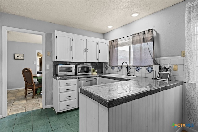 614 Cedar Dr, Copperas Cove, TX 76522 - kitchen with white cabinetry, a peninsula, a sink, a textured ceiling, and stainless steel appliances