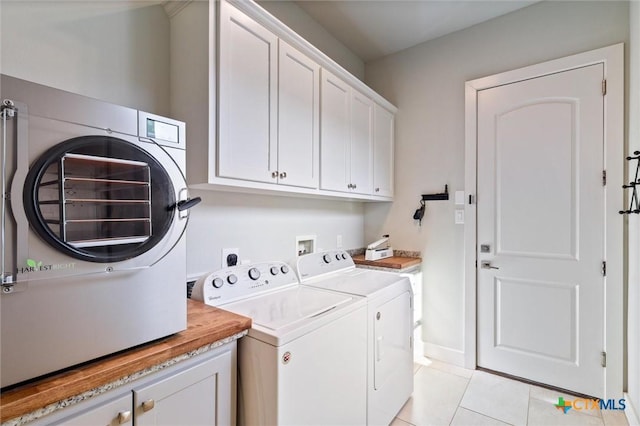 laundry room with cabinets, washing machine and clothes dryer, and light tile patterned flooring