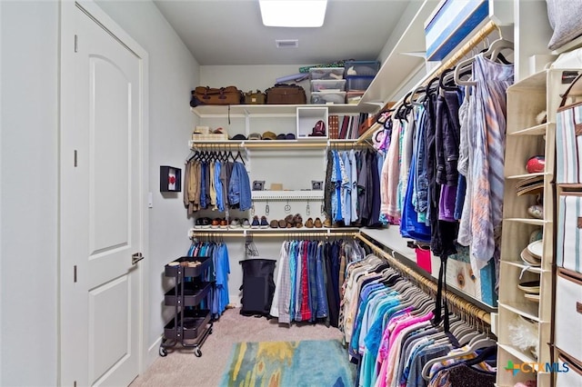 walk in closet featuring light colored carpet