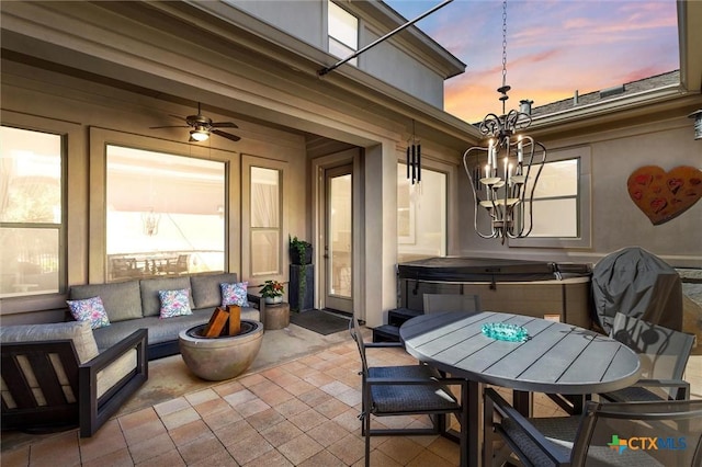 patio terrace at dusk with a hot tub and an outdoor living space