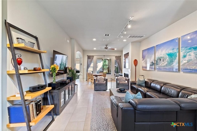 tiled living room featuring track lighting and ceiling fan