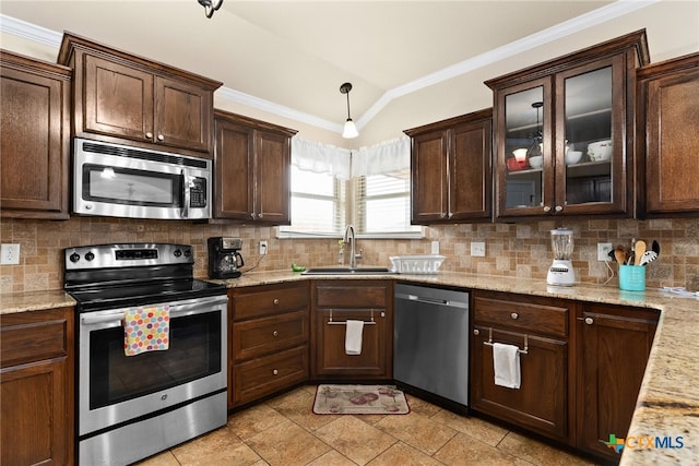 kitchen with sink, vaulted ceiling, tasteful backsplash, light stone counters, and stainless steel appliances