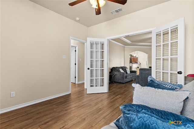 living area with hardwood / wood-style flooring, ceiling fan, and crown molding