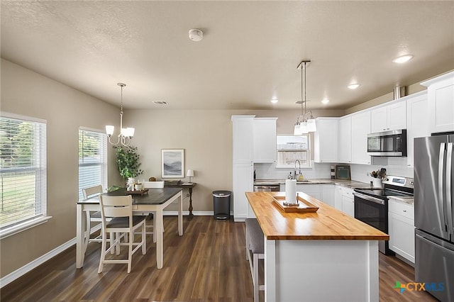 144 Slocum Dr, Canyon Lake, TX 78133 - kitchen featuring butcher block countertops, appliances with stainless steel finishes, a chandelier, baseboards, and recessed lighting