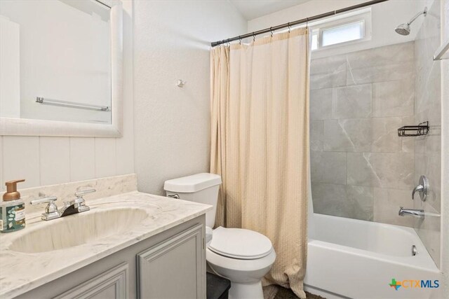 bathroom with vanity, shower / bath combination with curtain, and toilet