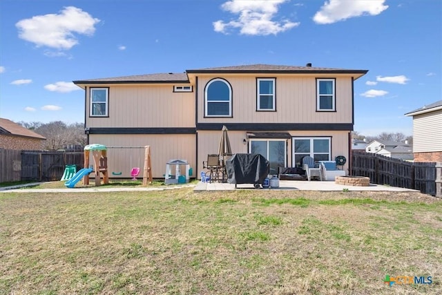 back of house featuring a playground, a yard, and a patio area