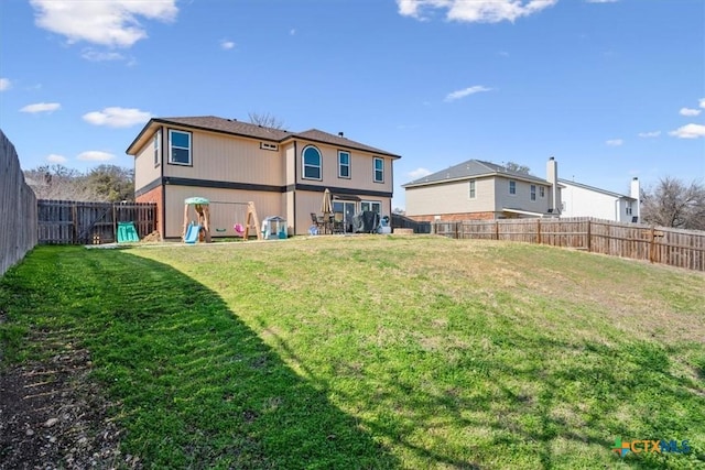 back of property with a yard and a playground