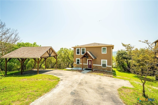 924 Kindersley St, Canyon Lake, TX 78133 - view of front of house featuring driveway, stone siding, a front yard, stucco siding, and a detached carport