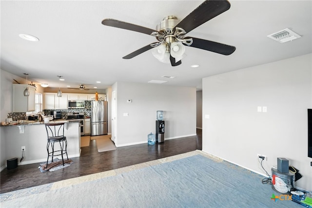 924 Kindersley St, Canyon Lake, TX 78133 - kitchen with appliances with stainless steel finishes, a peninsula, recessed lighting, backsplash, and a breakfast bar