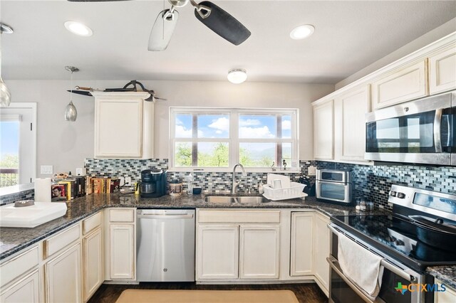 924 Kindersley St, Canyon Lake, TX 78133 - kitchen with appliances with stainless steel finishes, a sink, tasteful backsplash, ceiling fan, and a peninsula