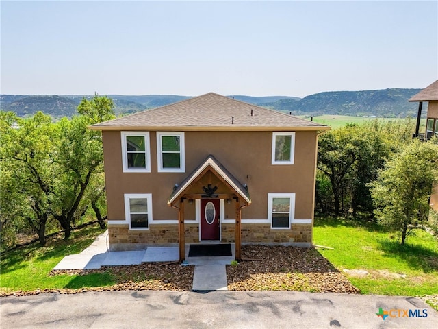 924 Kindersley St, Canyon Lake, TX 78133 - view of front of home with stone siding, stucco siding, a shingled roof, and a mountain view