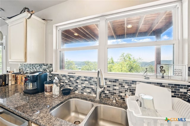 924 Kindersley St, Canyon Lake, TX 78133 - kitchen featuring decorative backsplash, plenty of natural light, dark stone counters, and white cabinets