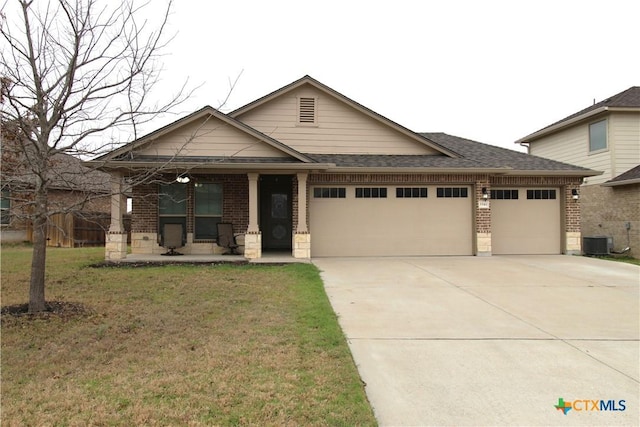 view of front of property featuring a garage, a front yard, brick siding, and driveway