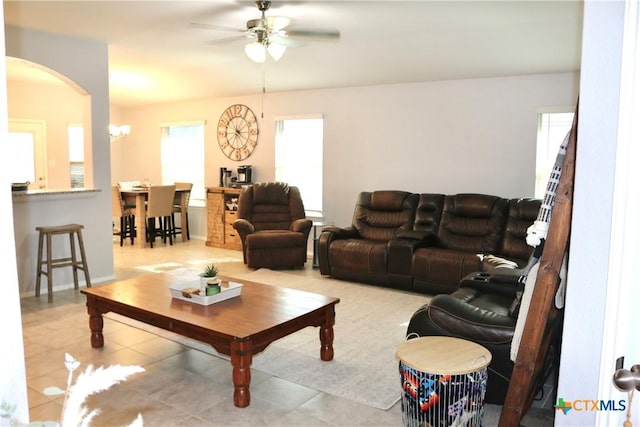 tiled living area with arched walkways and ceiling fan