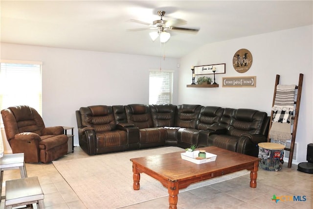 living area featuring lofted ceiling, light tile patterned floors, and a ceiling fan