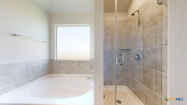 bathroom featuring independent shower and bath