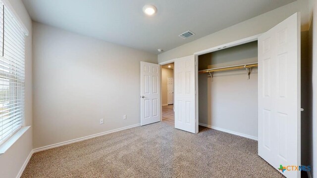 unfurnished bedroom with carpet flooring and a closet