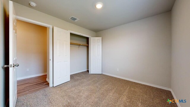 unfurnished bedroom with carpet flooring and a closet