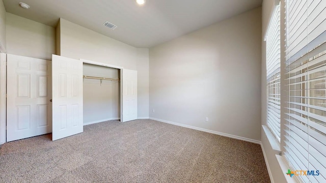 unfurnished bedroom featuring carpet and a closet