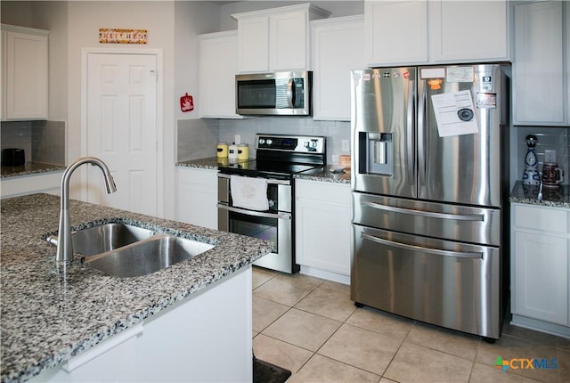 8915 Stonehollow Dr, Temple, TX 76502 - kitchen with stainless steel appliances, a sink, decorative backsplash, white cabinets, and light tile patterned flooring
