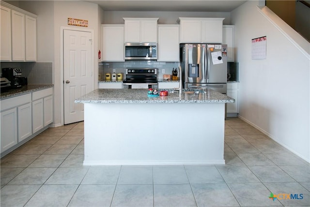 8915 Stonehollow Dr, Temple, TX 76502 - kitchen with appliances with stainless steel finishes, decorative backsplash, a kitchen island with sink, and light tile patterned floors
