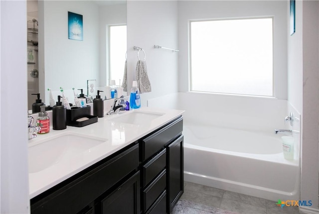 8915 Stonehollow Dr, Temple, TX 76502 - bathroom with plenty of natural light, a bath, double vanity, and tile patterned flooring